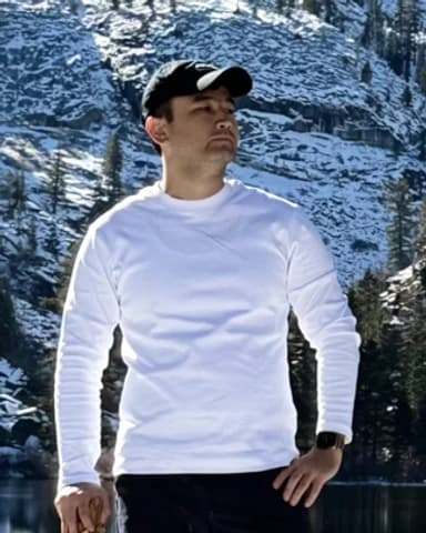 Rovshen Nurybayev standing at a frozen mountain lake