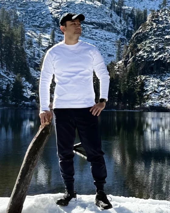 Rovshen Nurybayev standing at a frozen mountain lake